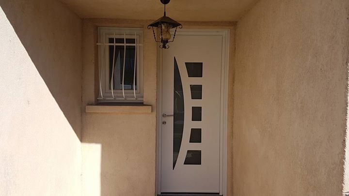 Après les travaux : nouvelle porte d'entrée blanche contemporaine avec hublots carrés et vitrage en arc, sous le même porche