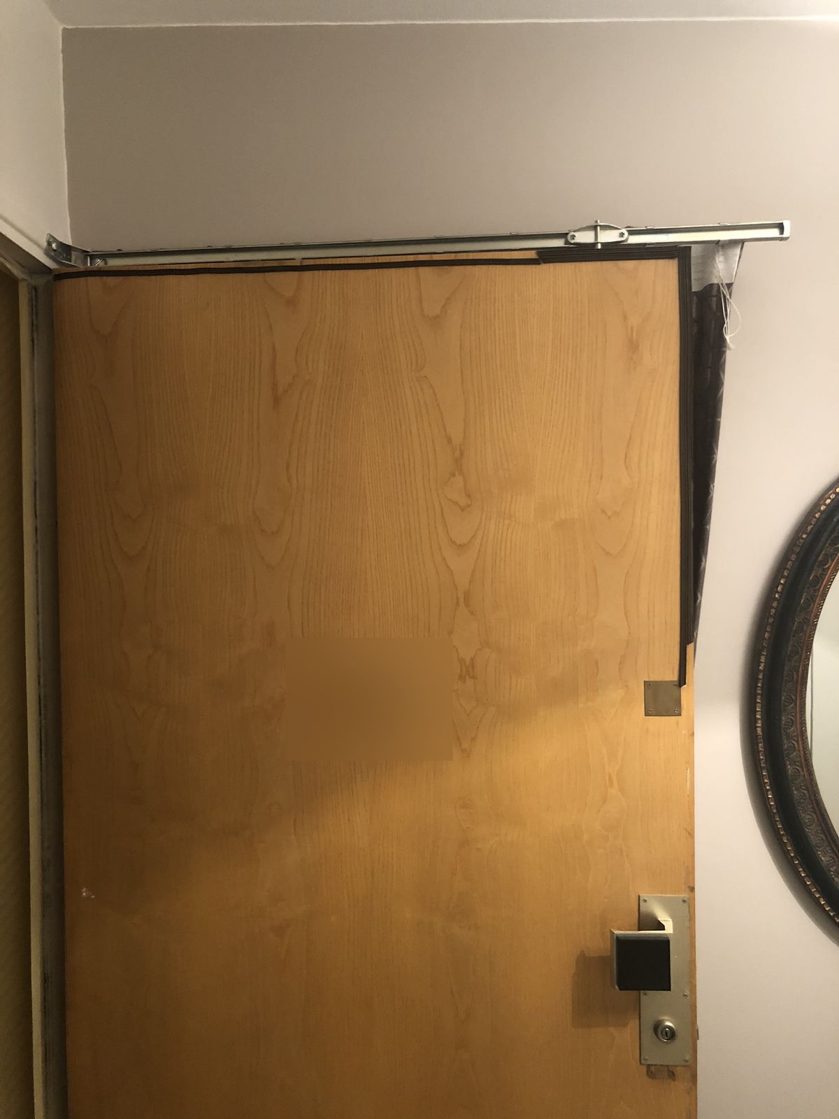 Porte palière en bois renforcée par une cornière métallique et une serrure en applique