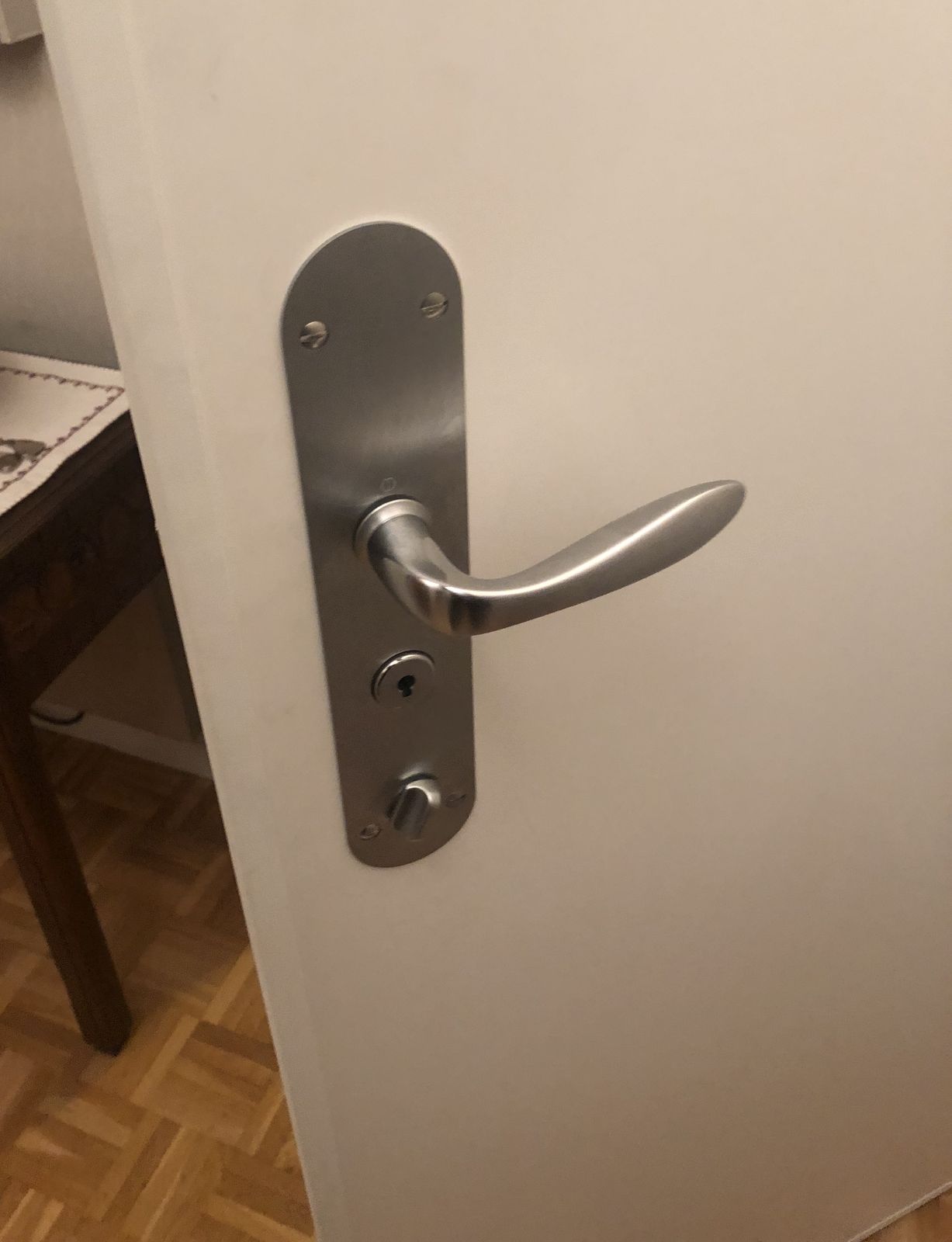 Poignée et plaque de serrure inox sur la face intérieure d'une porte blindée