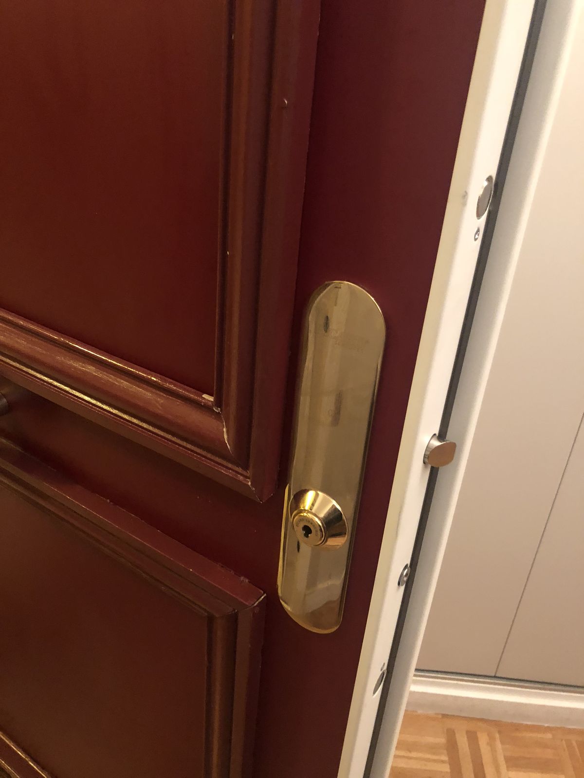 Détail de serrure et de chant d'une porte blindée bordeaux
