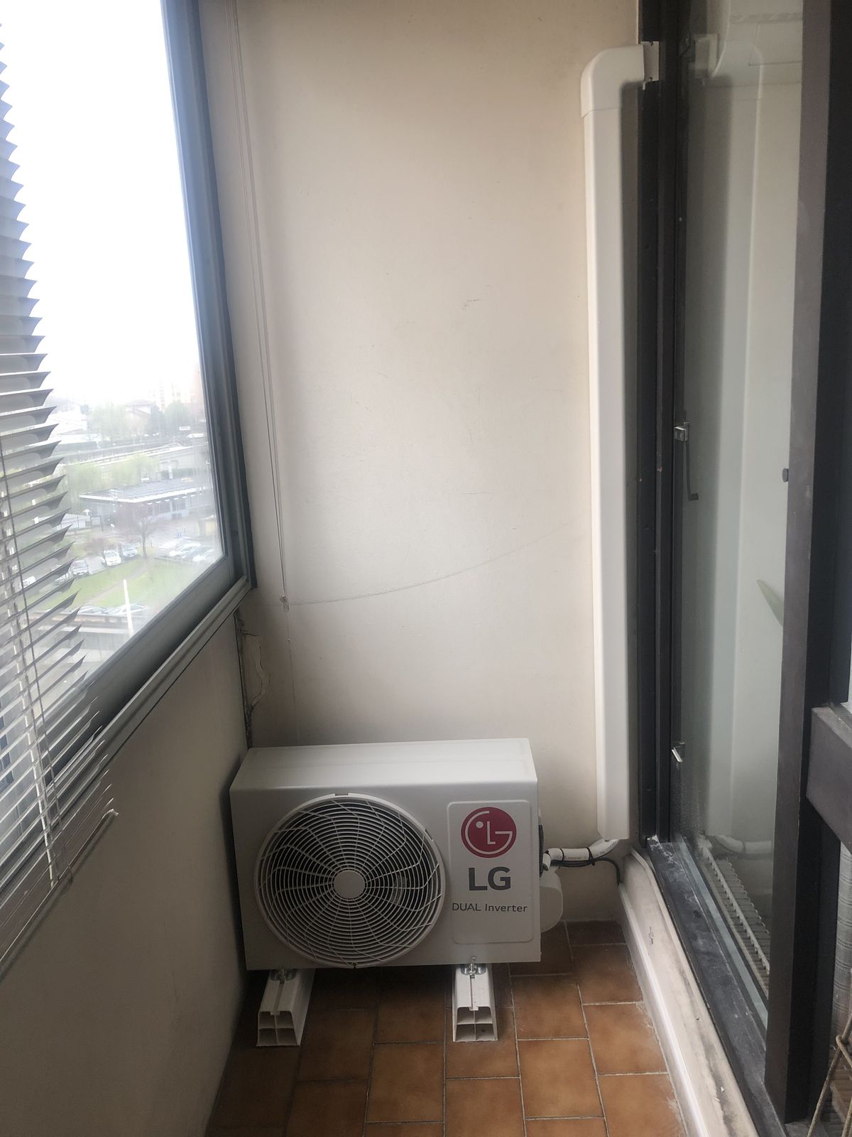 Unité extérieure de climatisation installée dans l'angle d'une loggia