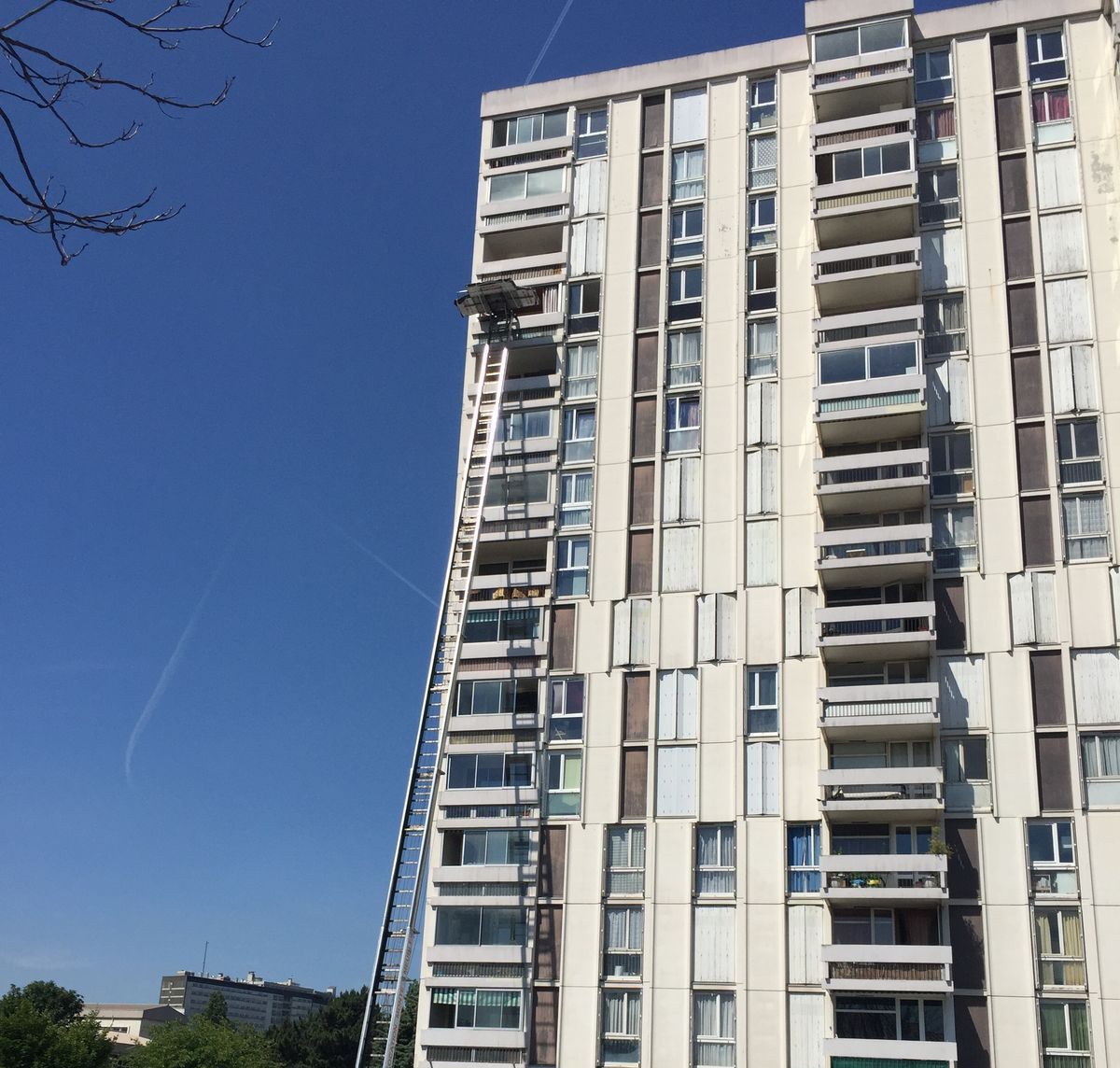 Monte-matériaux déployé le long d'une tour d'habitation pour un chantier de menuiseries en étage
