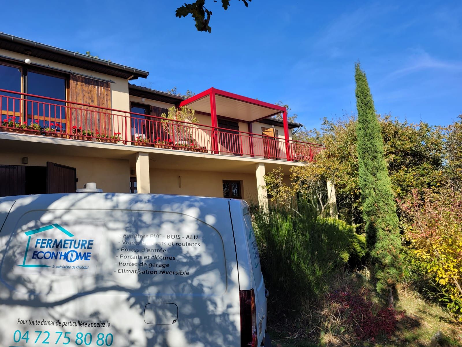 Utilitaire blanc floqué Fermeture Econ'Home stationné devant une maison sous un ciel bleu