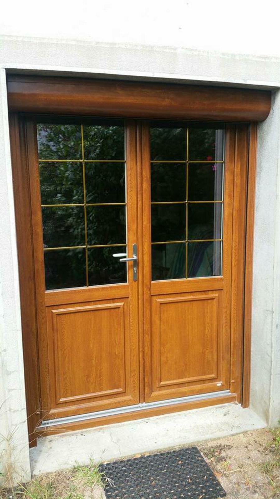Porte-fenêtre deux vantaux ton chêne avec petits bois dorés et coffre de volet roulant assorti