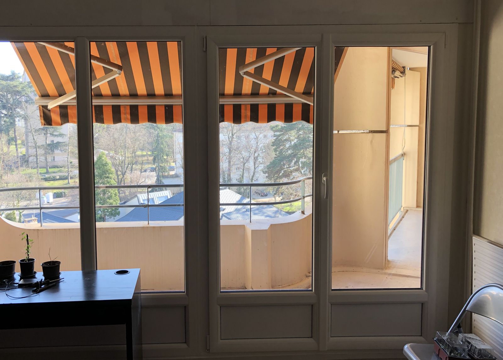 Ensemble porte-fenêtre et fenêtres en PVC blanc à soubassements, ouvrant sur un balcon