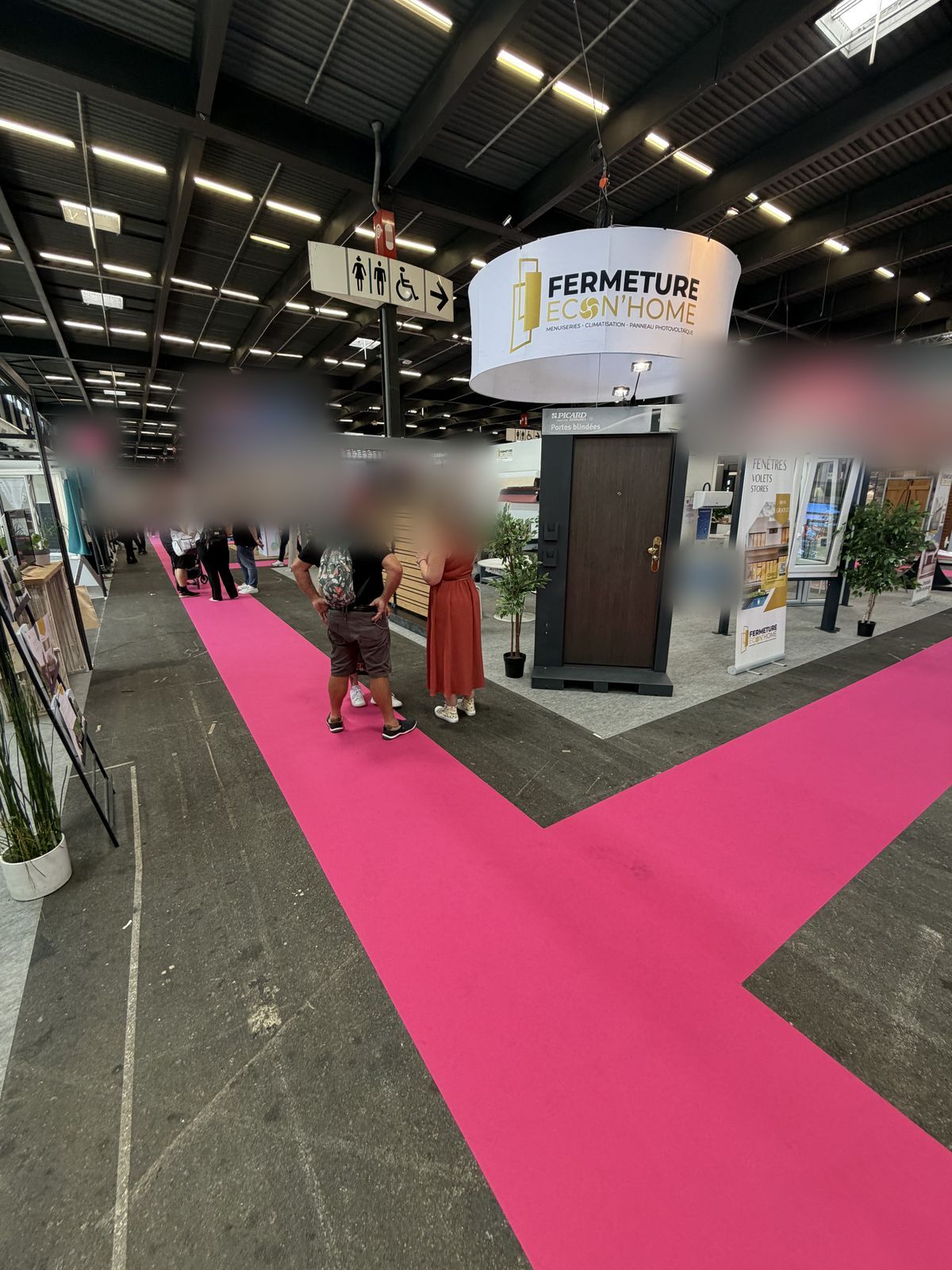 Le stand vu depuis l'allée centrale de la foire, sous l'enseigne ronde Fermeture Econ'Home