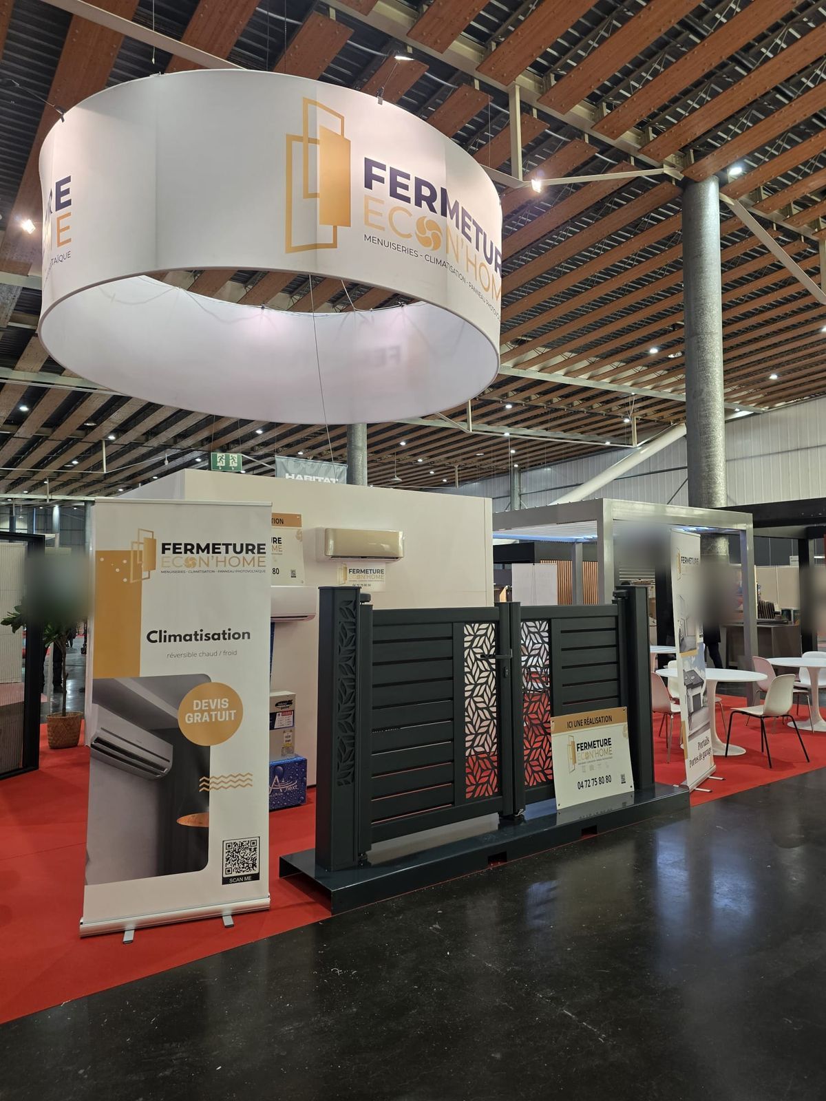 Portail en aluminium à motif ajouré, climatiseur mural et kakémono climatisation exposés sur le stand