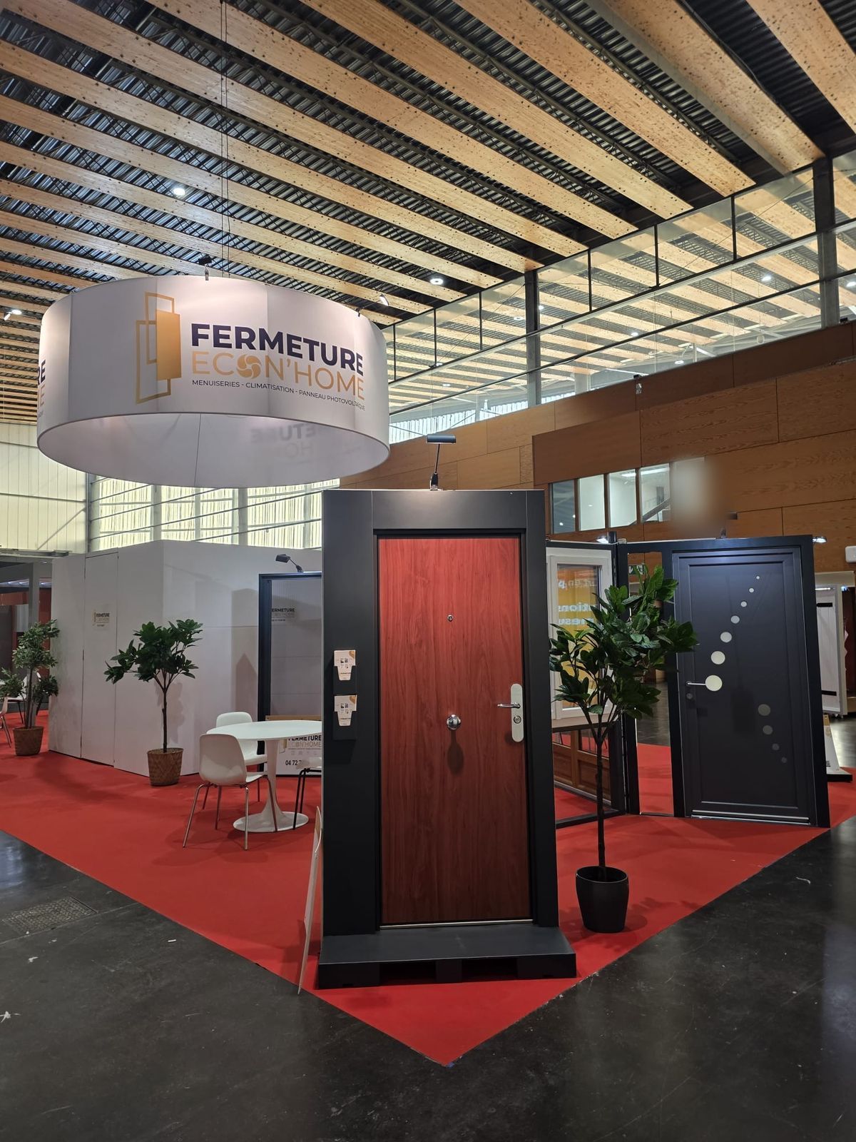 Porte d'entrée ton bois rouge et porte d'entrée grise exposées sous l'enseigne ronde