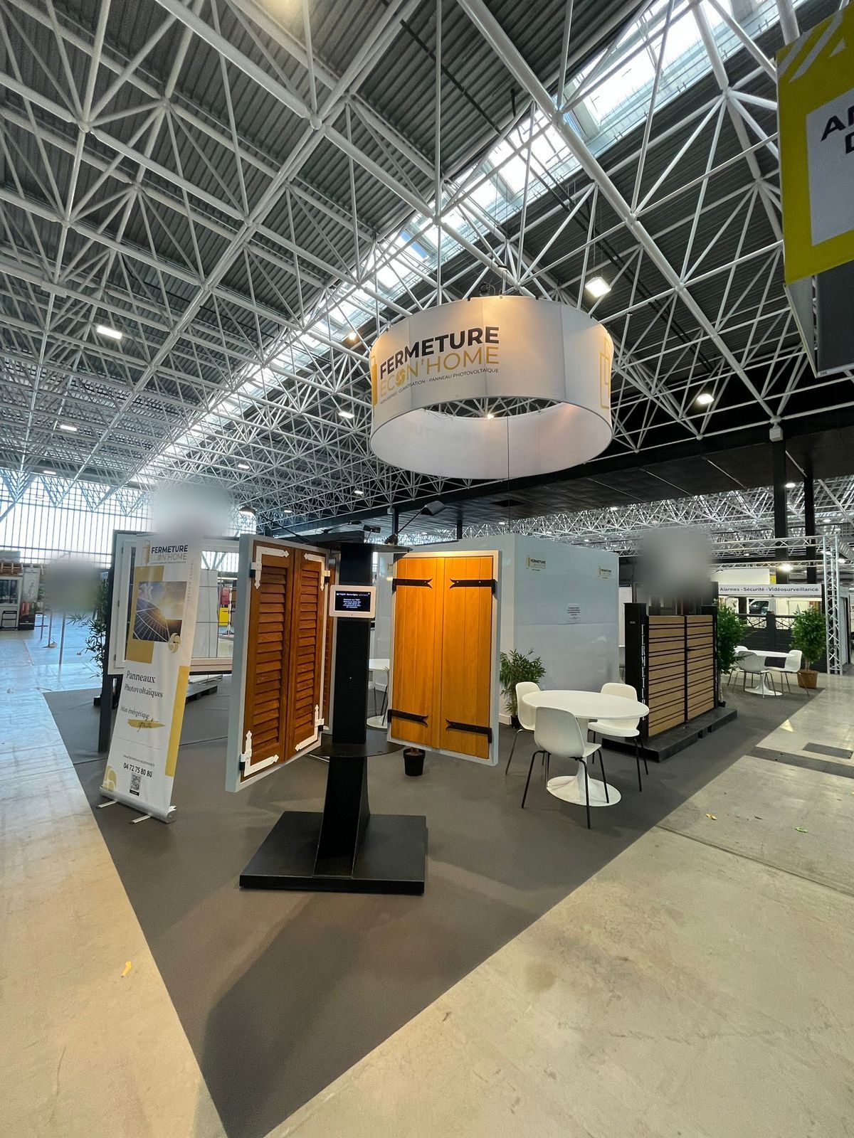 Présentoir de volets battants ton bois, clôture et kakémono panneaux photovoltaïques sur le stand