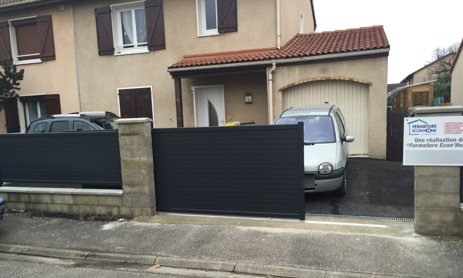 Portail coulissant et clôture gris anthracite à lames horizontales devant une maison