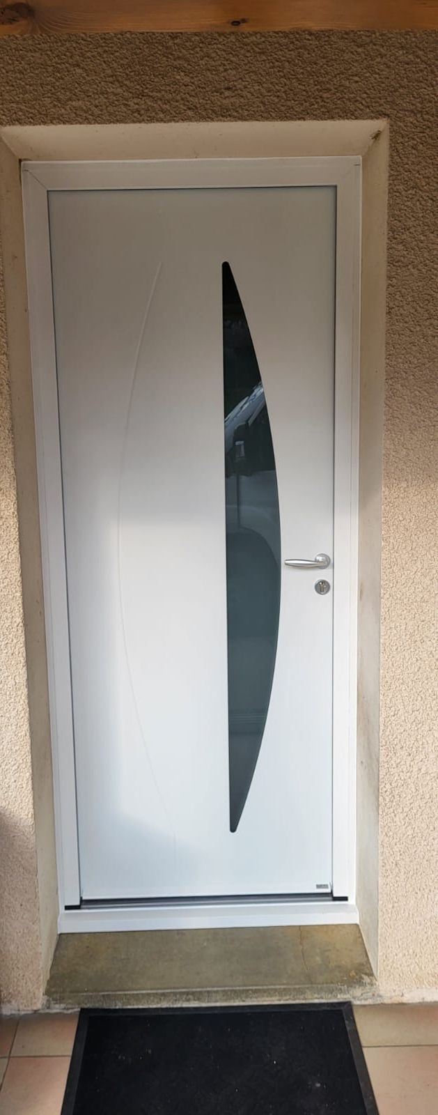Porte d'entrée blanche avec un vitrage étroit en forme d'arc