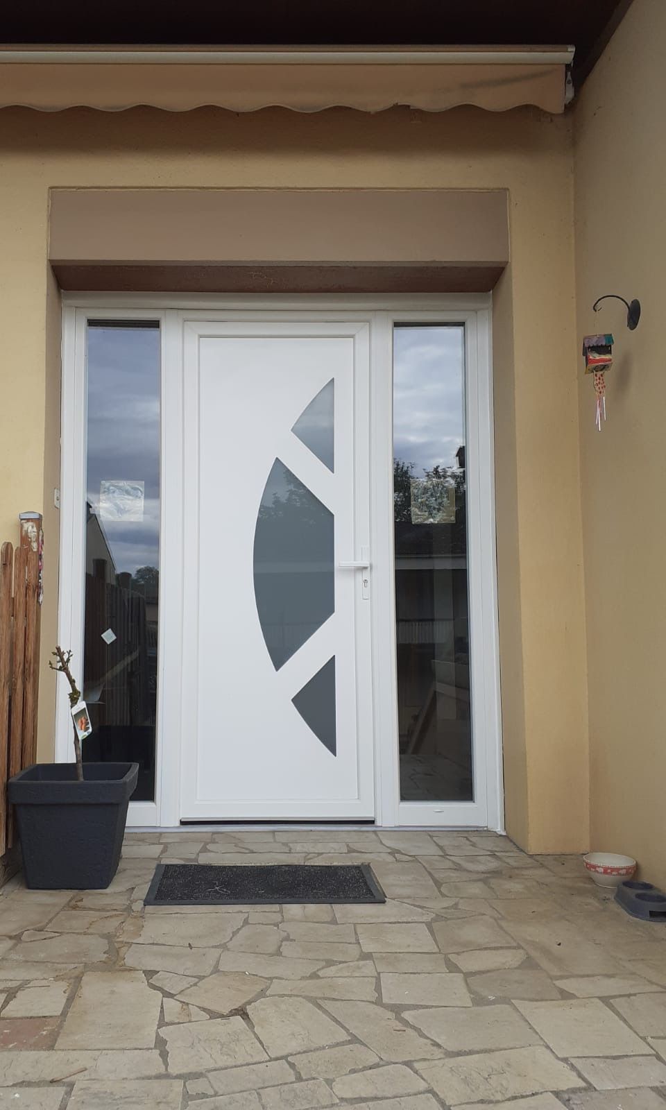 Porte d'entrée blanche à vitrages décoratifs avec deux fixes latéraux vitrés