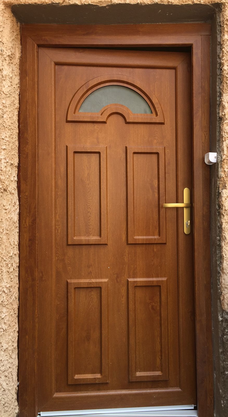 Porte d'entrée ton chêne doré à panneaux moulurés et petit vitrage en demi-lune