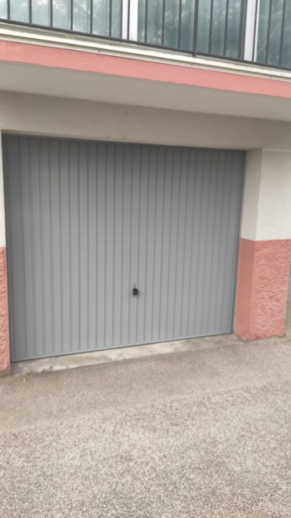Porte de garage basculante grise à rainures verticales