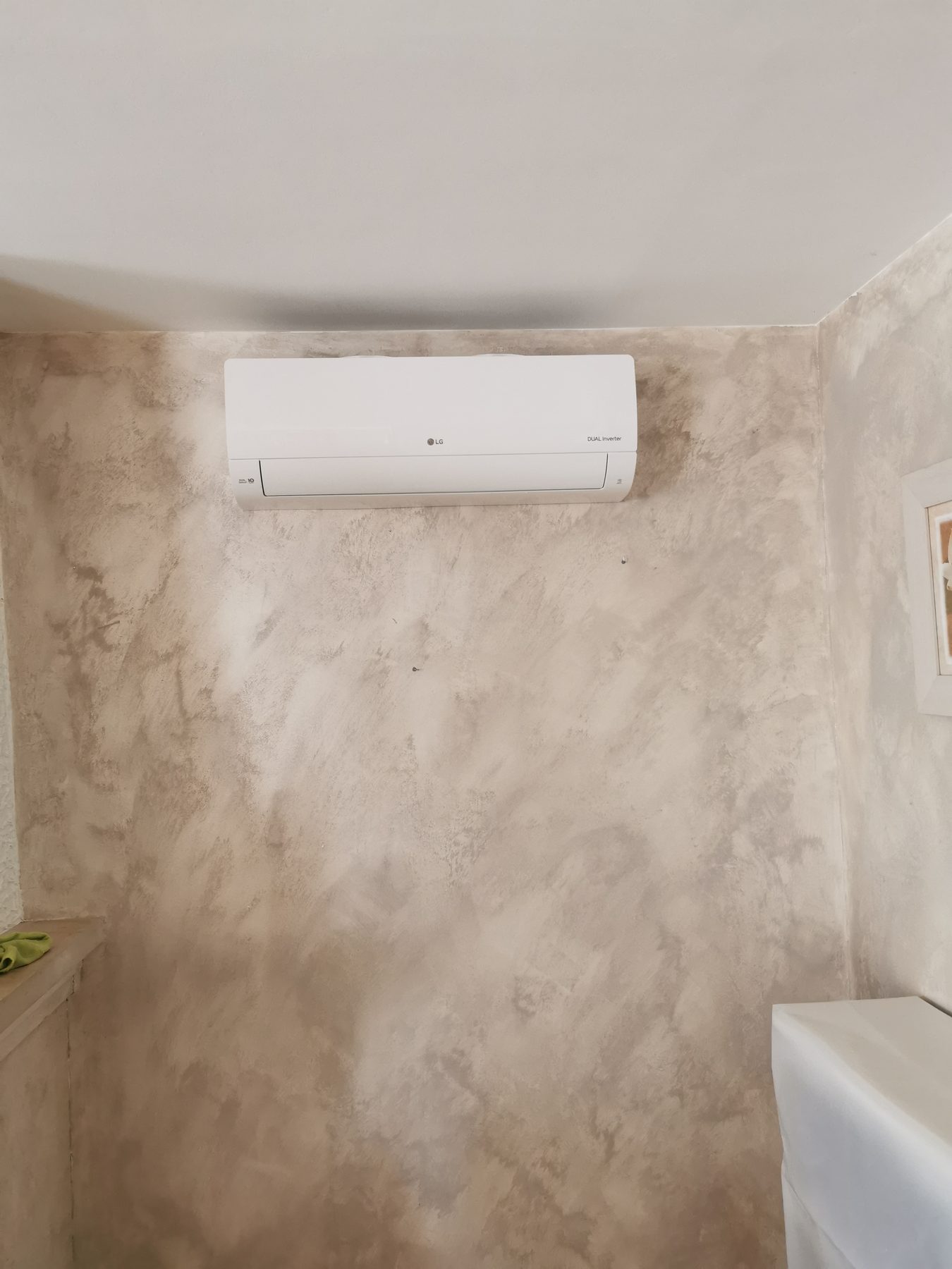 Unité intérieure de climatisation LG posée sur un mur à enduit décoratif